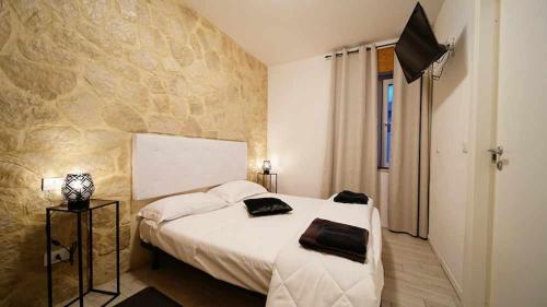 维罗纳Langolo di laura borgo roma destiny home 3的一间卧室设有一张床和石墙