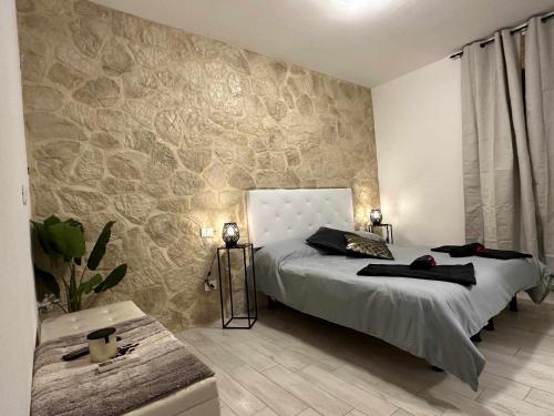 维罗纳Langolo di laura borgo roma destiny home 3的一间卧室配有一张石墙床