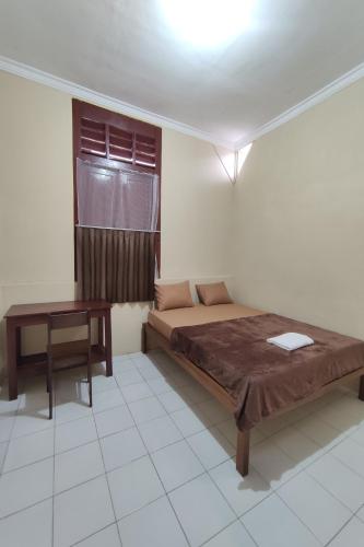 日惹OYO 93173 Khazanah Room Syariah的一间卧室配有一张床和一张桌子