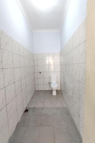 日惹OYO 93173 Khazanah Room Syariah的一间铺有白色瓷砖的客房内浴室,内配卫生间