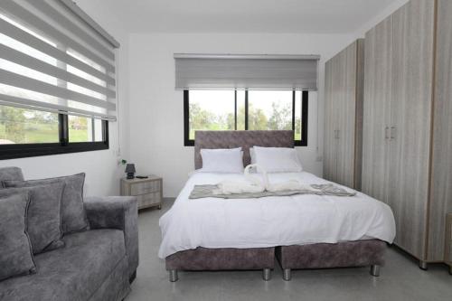 Poriyyaאחוזת העמק סוויטות בפוריה的一间卧室配有一张大床和一张沙发