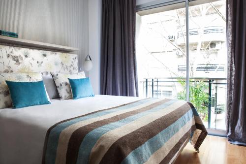 布宜诺斯艾利斯博芳特公寓式酒店的酒店客房设有一张带大窗户的床。
