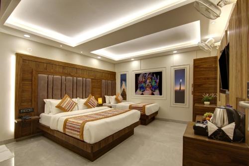 新德里BLESS INN - Near Connaugt Place的酒店客房设有两张床和电视。