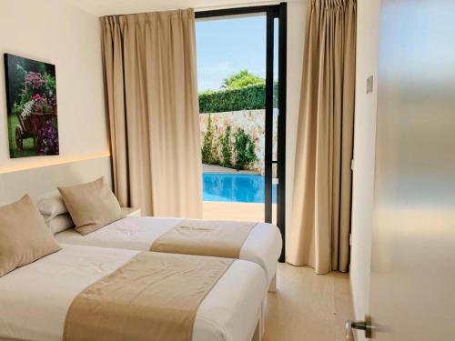 卡拉恩·布拉內斯Villa SONIA的配有大窗户的酒店客房内的两张床