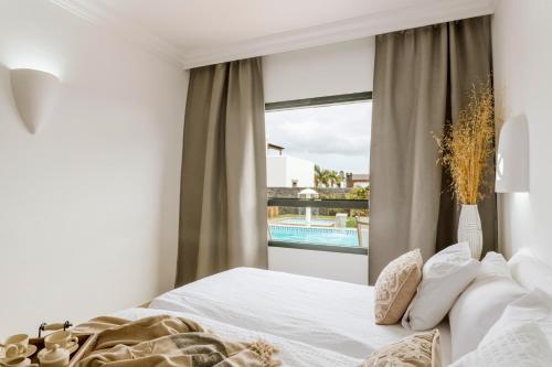 普拉亚布兰卡Villa Marabú的一间卧室设有一张床和一个带游泳池的窗户