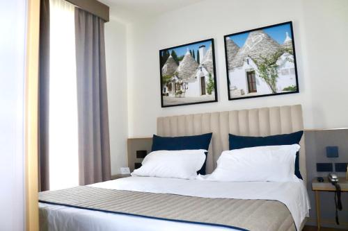 巴里维多利亚公园酒店 的卧室配有一张墙上三幅照片的床