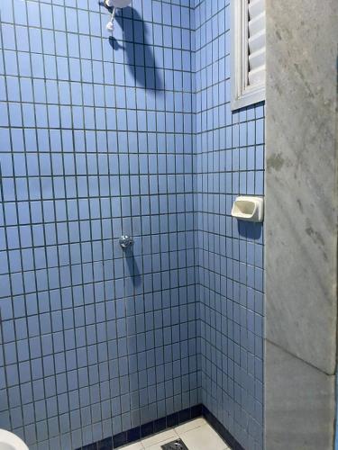 贝洛奥里藏特Hotel Angely的带淋浴的浴室和蓝色瓷砖墙壁