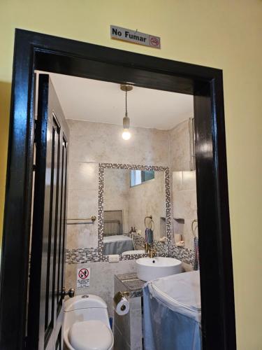 瓜亚基尔Blanca Apartments的一间带卫生间、水槽和镜子的浴室