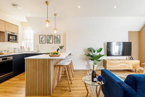 伯恩茅斯Sea Breeze - Coast的厨房以及带蓝色沙发的客厅。