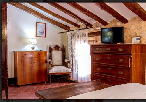 PenáguilaCasa Valor的一间卧室配有梳妆台、电视和椅子