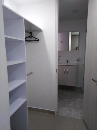圣罗莎德卡瓦尔Apartamento 3 hab 2 baños的一间设有白色架子和厨房的房间