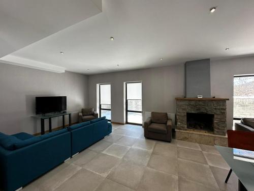 巴库里阿尼BANOVANI Bakuriani的客厅设有蓝色的沙发和壁炉