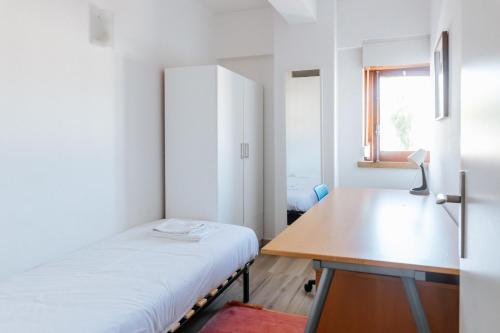 里斯本Lisboa - Ajuda Palace Apartment的一间卧室配有一张床、一张书桌和一个窗户。