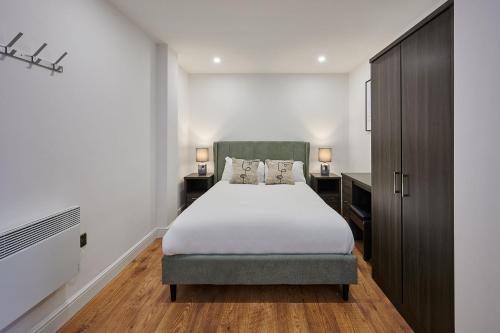利物浦Host & Stay - Sevenstays Aparthotel的一间卧室设有一张大床和两个床头柜