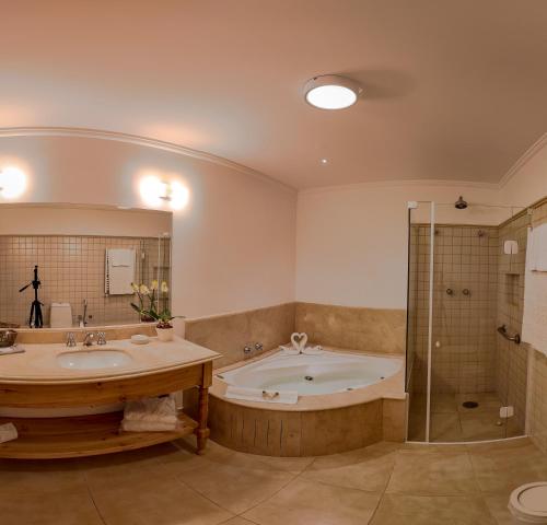 坎波斯杜若尔当Hotel Solar d'Izabel的带浴缸、两个盥洗盆和淋浴的浴室。