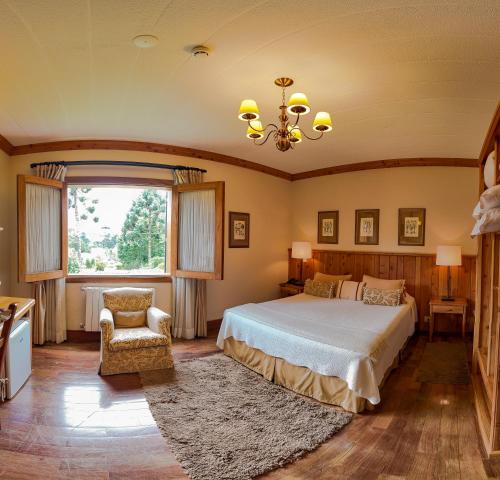 坎波斯杜若尔当Hotel Solar d'Izabel的卧室配有床、椅子和窗户。