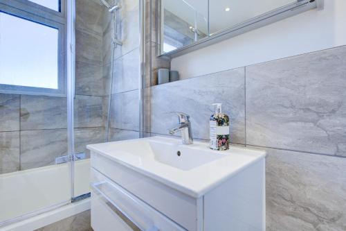 罗姆福特Exquisite 5-Bedroom in London and Essex - Sleeps 10 with Free Parking的浴室配有白色水槽和淋浴。