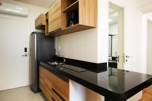 伊列乌斯Ilhéus Praia Hotel的厨房配有黑色台面和冰箱