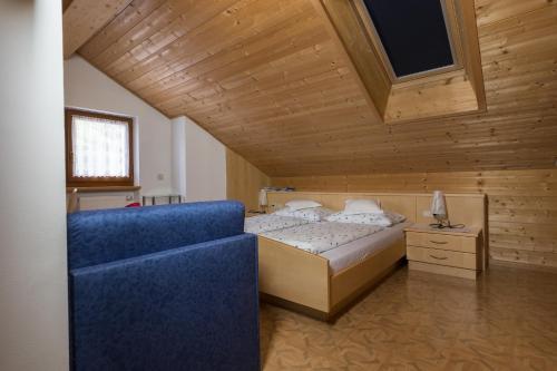 拉伊翁Zehentnerhof的一间卧室配有一张床和一张蓝色的沙发