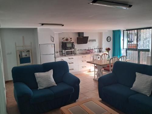 梅里那德奥拉菲Alojamiento Casa Piano的一间带2张蓝色沙发的客厅和一间厨房