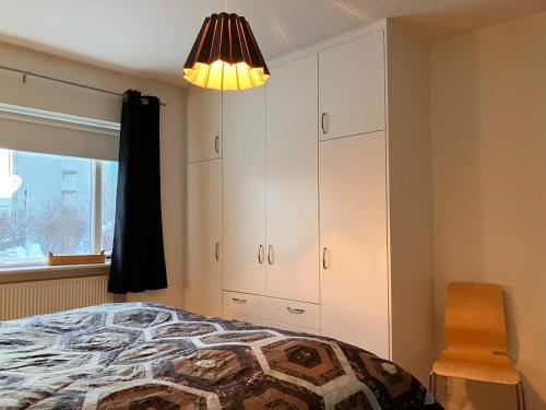 阿克雷里Great apartment in Akureyri的一间卧室配有一张床、一把椅子和一盏灯