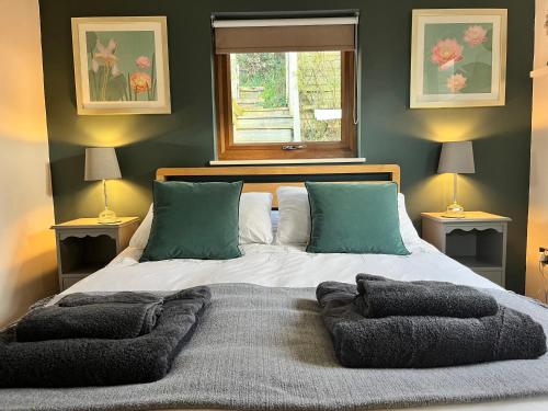 切尔滕纳姆Wellinghill Lodge的一间卧室配有一张带两盏灯的床和一扇窗户。