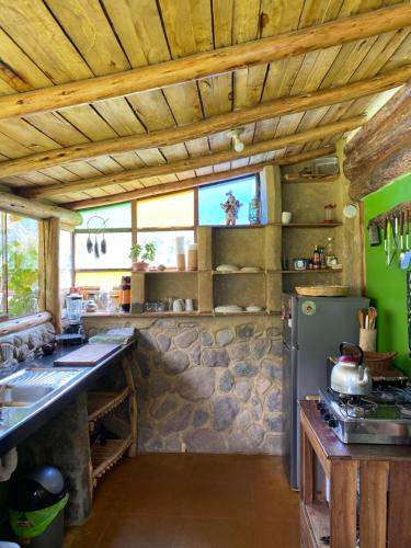 奥兰太坦波Cabaña del viajero.的厨房设有石墙和冰箱。