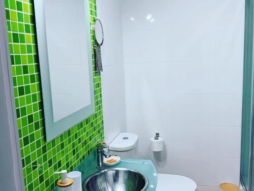 阿尔姆尼卡Playa Velilla Velimar 2的绿色瓷砖浴室设有水槽和卫生间