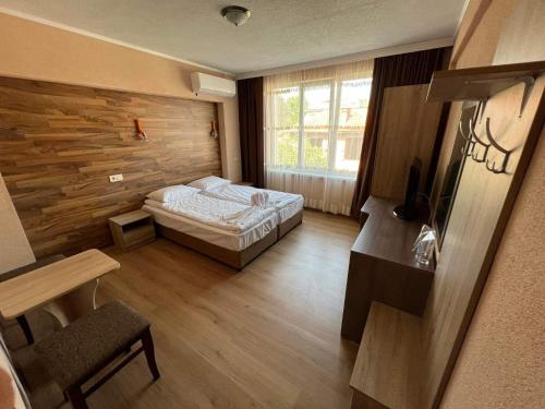 斯特雷尔恰Бонита Хотел Спа的一间卧室设有一张床和木墙
