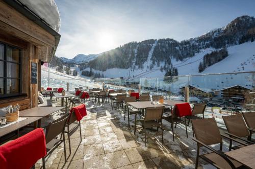 扎奥岑湖奥鹏霍夫高级酒店的滑雪场上带桌椅的餐厅