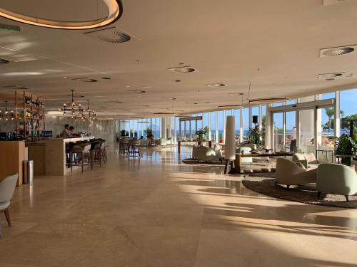 里约热内卢Hotel Nacional RJ - Vista Mar的大型大堂设有桌椅和窗户。