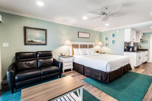 帕瓦雷斯岛Dunes King Room Oceanfront Views 2nd Floor的一间卧室配有一张床、一张沙发和一把椅子