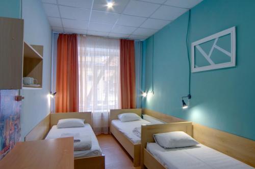 基辅珀多斯基旅舍的客房设有两张床、一张桌子和一扇窗户。