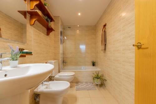 利乌玛SUNSET HOLIDAY RIUMAR的浴室配有盥洗盆、卫生间和浴缸。
