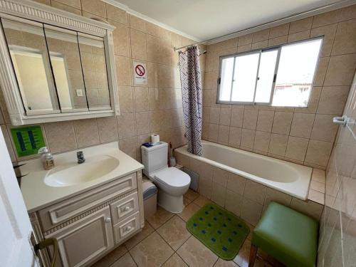 拉塞雷纳Hostal del Rosario La Serena的浴室配有盥洗盆、卫生间和浴缸。