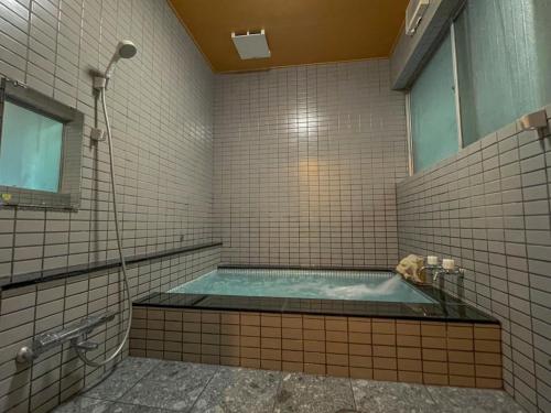 天草市Eimiya Ryokan - Vacation STAY 36263v的一间带按摩浴缸和窗户的浴室