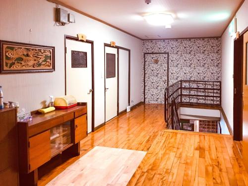 天草市Eimiya Ryokan - Vacation STAY 36252v的客厅铺有木地板,拥有白色的墙壁。