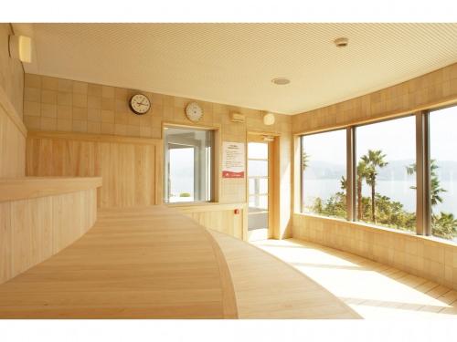 天草市Hotel Alegria Gardens Amakusa - Vacation STAY 40453v的墙上挂有时钟的空房间