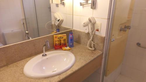 马瑙斯###SENSACIONAL### MERCURE APART HOTEL PREMIUM的一个带水槽和电话的浴室台面