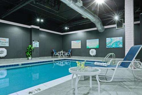 斯坦福德Armon Hotel & Conference Center Stamford CT的游泳池旁设有椅子和桌子