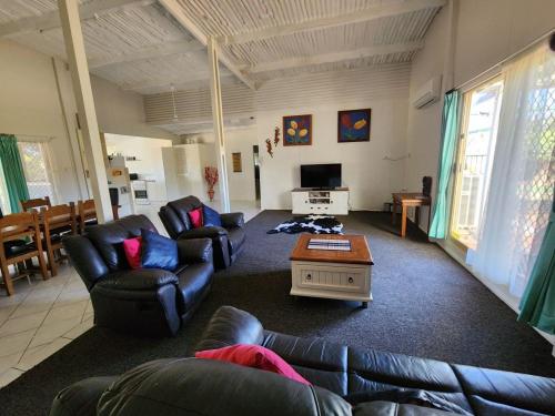 GinginCountry Retreat The Blue Cottage的客厅配有真皮沙发和电视