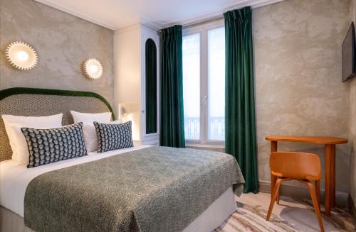 巴黎Hotel des Carmes by Malone的一间卧室配有一张带绿色窗帘的床和窗户。