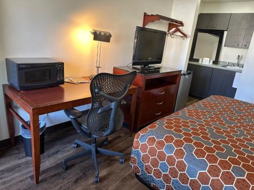 阿尔伯克基Desert Sands Inn & Suites的客房设有一张书桌、一台电脑和一张床