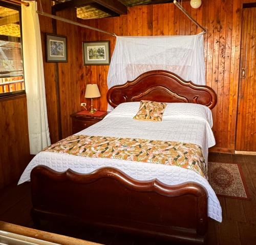 巴亚索拉诺Posada Turística Rocas De Cabo Marzo的一间卧室设有一张带木墙的大床