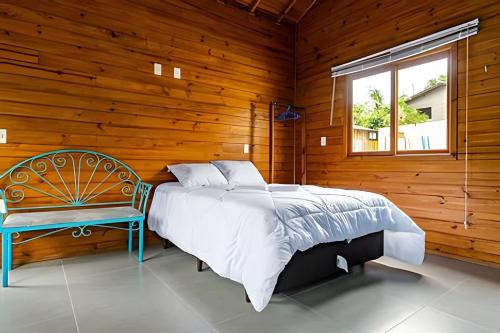 弗洛里亚诺波利斯Cabanas aconchegantes. Desfrute da natureza e praia的卧室配有床、椅子和窗户。