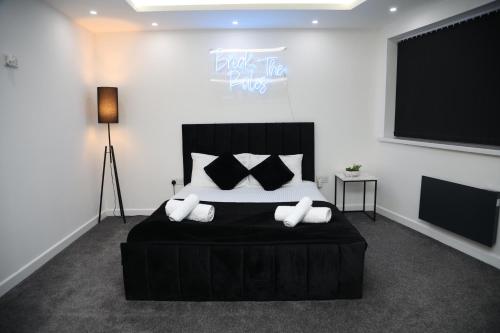 伯明翰The Hideaway的一间卧室配有一张带枕头的大型黑色床。