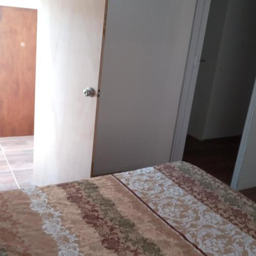 FloridaHostal DOÑA EMMA的一间卧室配有一张带棕色和白色被子的床