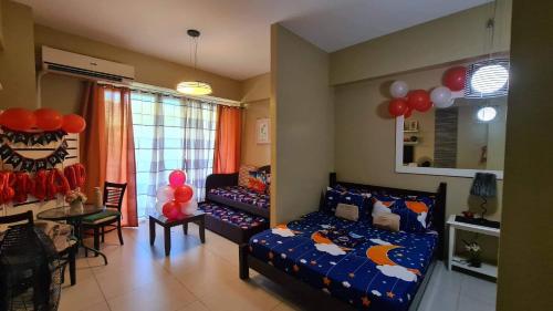 纳苏格布Pico de Loro Staycation (3 beds- 6 pax)的一间卧室配有一张床、一张桌子和气球