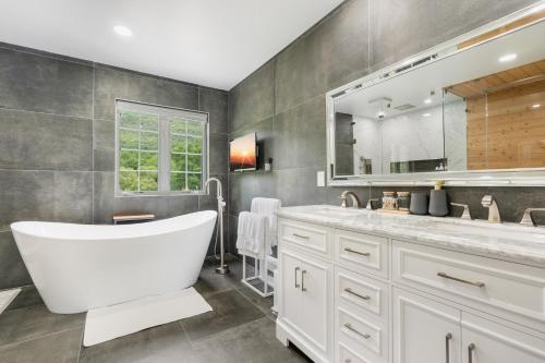 WoodburyMalkita’s Mountain View Villa的一间带浴缸和大镜子的浴室
