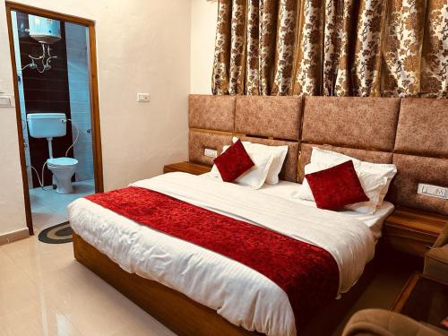 西姆拉The Aston Hills - A Luxury Stay , Shimla的一间卧室配有一张带红色枕头的大床